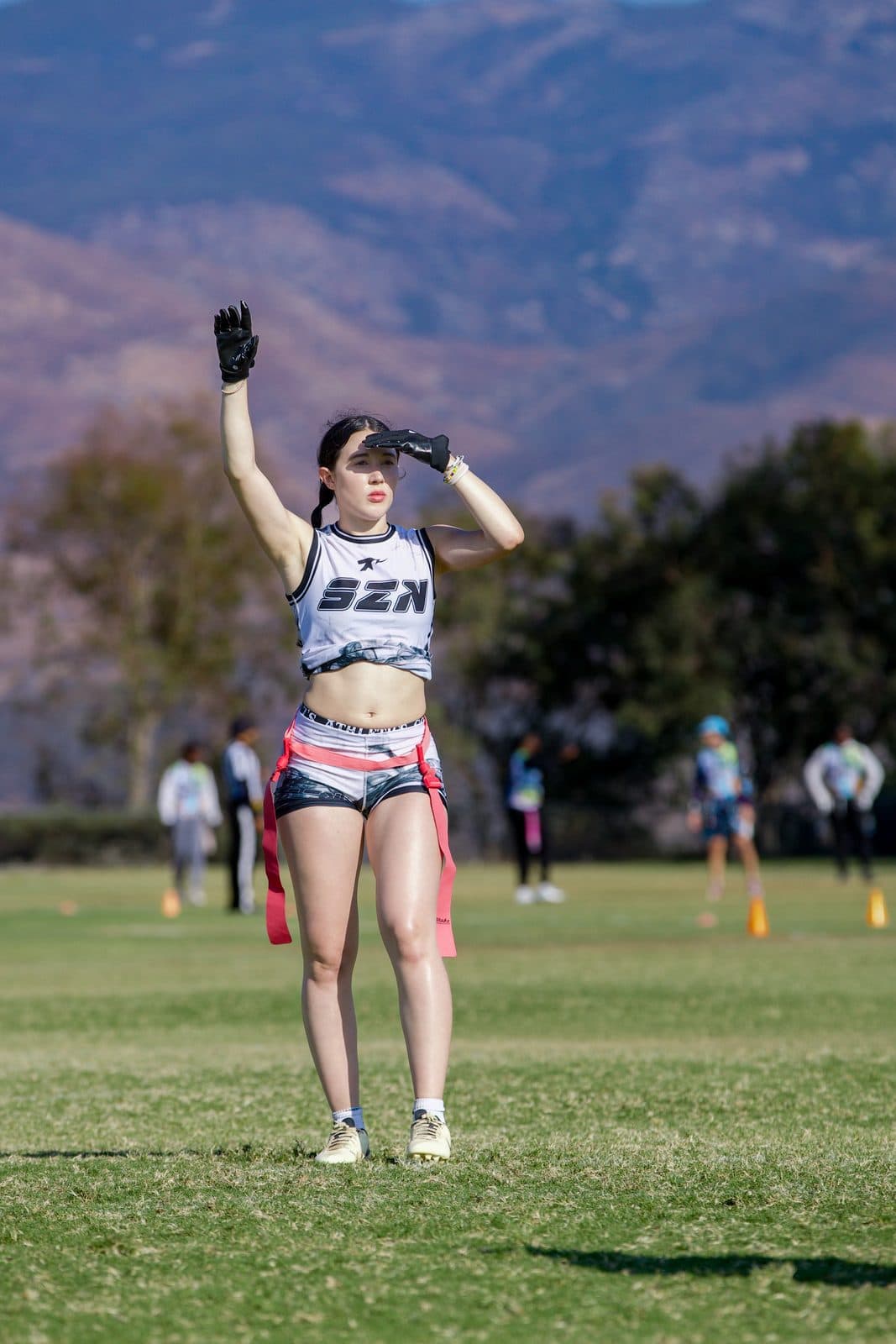 IN SZN player raising one arm on the field in her SZN jersey